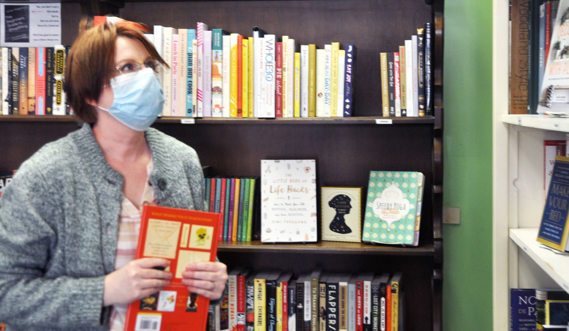 Bookstore employee wears face mask as stores reopen during pandemic